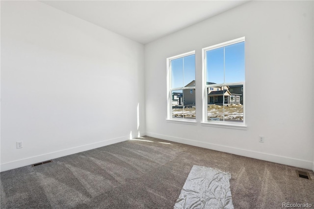 carpeted empty room featuring baseboards and visible vents