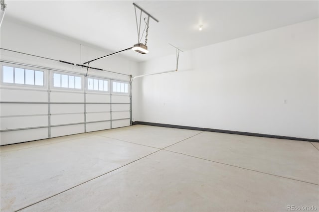 garage featuring a garage door opener and baseboards