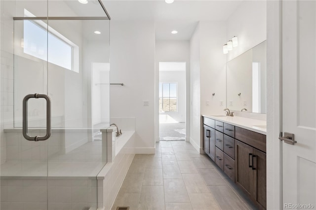 bathroom with a garden tub, a shower with door, double vanity, a sink, and tile patterned flooring