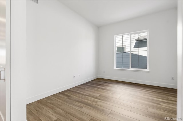 empty room with light wood-style floors and baseboards