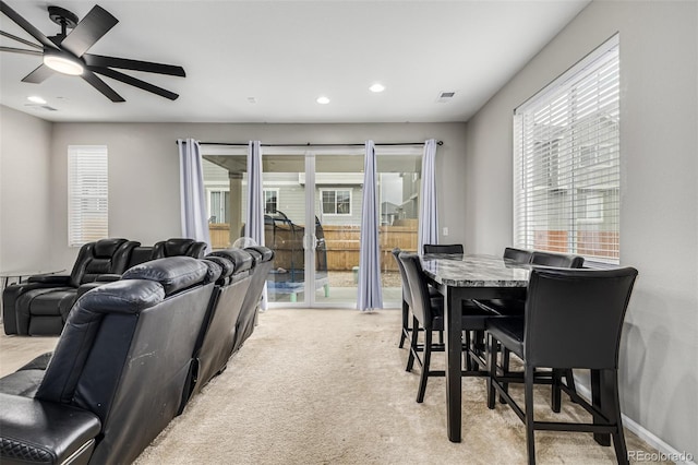 carpeted dining room featuring ceiling fan