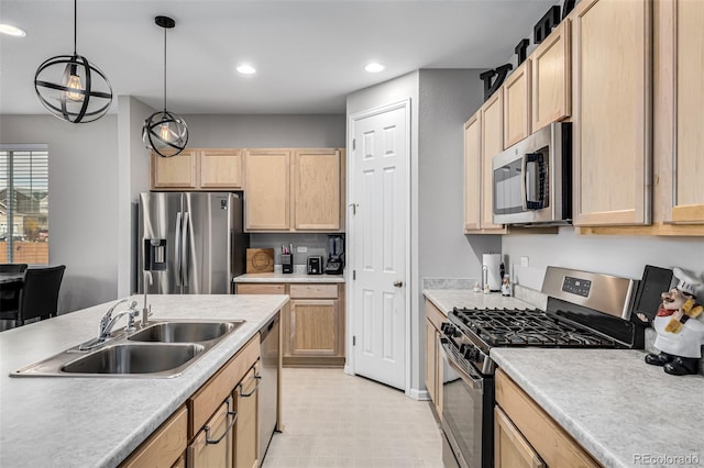 kitchen with stainless steel appliances, light brown cabinets, sink, and pendant lighting