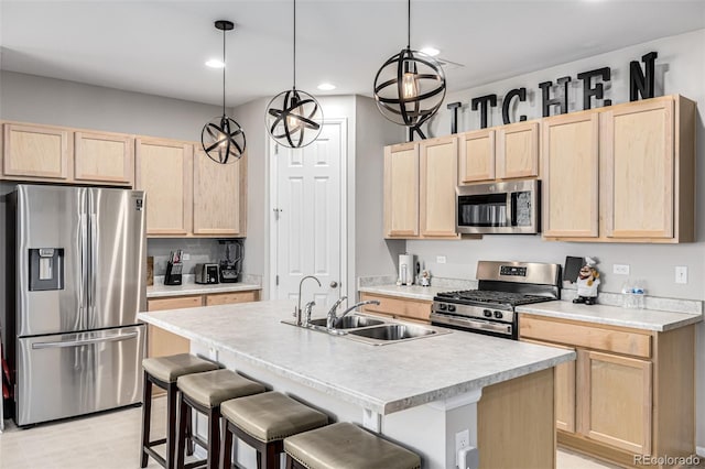 kitchen featuring sink, light brown cabinets, decorative light fixtures, and appliances with stainless steel finishes