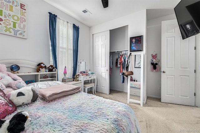 bedroom featuring ceiling fan, light colored carpet, and a closet