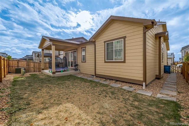 back of house featuring a patio and a lawn