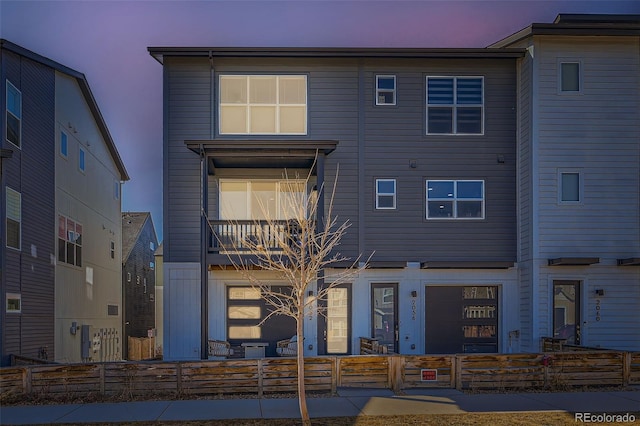 view of front of home featuring a fenced front yard and a balcony