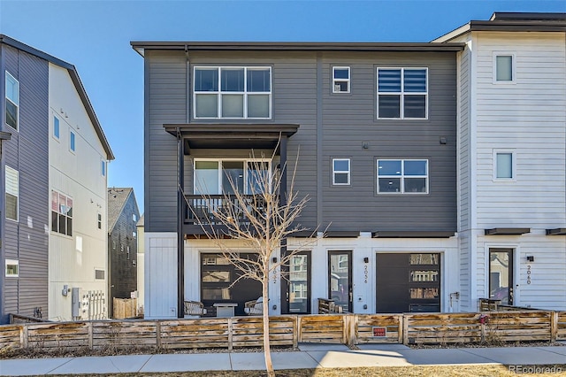 view of front of property featuring a fenced front yard and a balcony