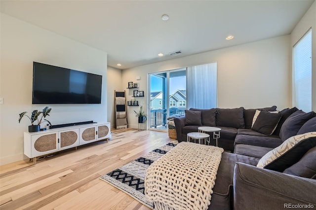 living area with recessed lighting, visible vents, baseboards, and wood finished floors