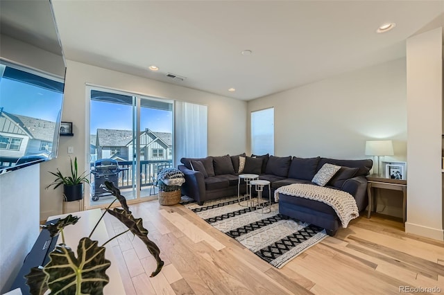 living area with light wood-style flooring, visible vents, and recessed lighting