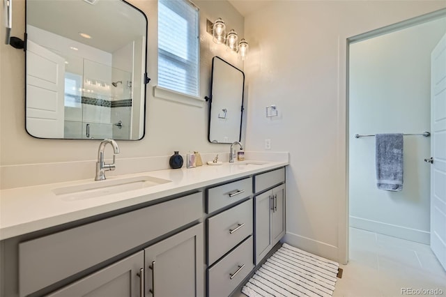 full bathroom featuring double vanity, a stall shower, tile patterned flooring, and a sink