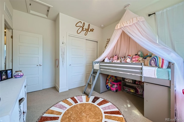 carpeted bedroom featuring a closet, visible vents, and attic access