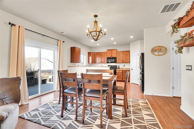 dining room featuring light wood-type flooring, visible vents, recessed lighting, and a notable chandelier