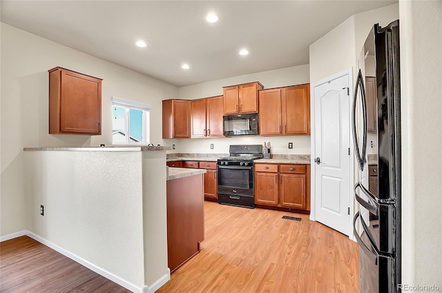 kitchen with black appliances, brown cabinets, light wood-type flooring, light countertops, and recessed lighting
