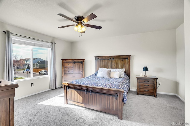 bedroom with a ceiling fan, baseboards, and carpet
