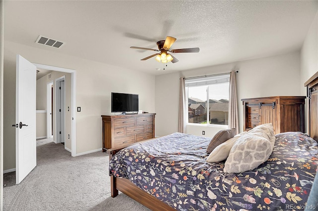 bedroom featuring carpet, visible vents, baseboards, a textured ceiling, and ceiling fan