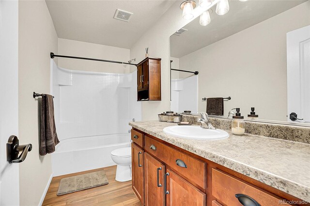 full bathroom featuring toilet, shower / bathtub combination, visible vents, wood finished floors, and vanity