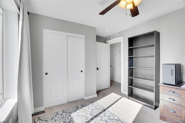 unfurnished bedroom featuring baseboards, visible vents, carpet, a ceiling fan, and a closet