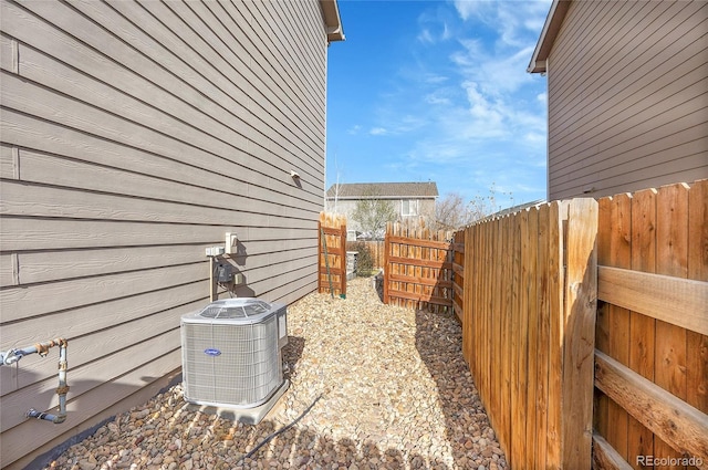 view of side of home with cooling unit and fence