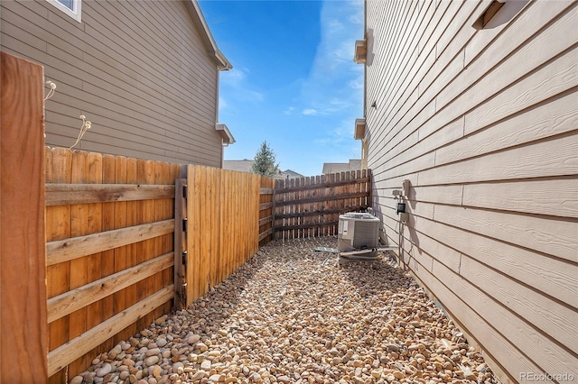 view of side of home featuring fence and cooling unit