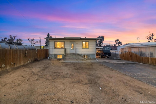 view of front of home featuring fence and solar panels