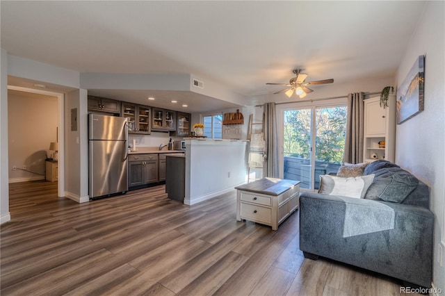 living room with dark wood-type flooring and ceiling fan