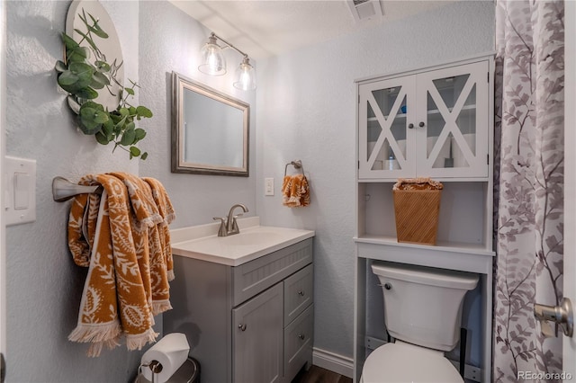 bathroom with vanity, hardwood / wood-style flooring, and toilet