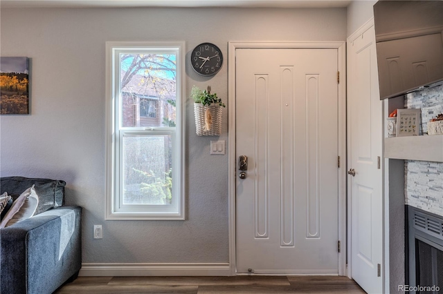 foyer entrance with a fireplace and wood-type flooring