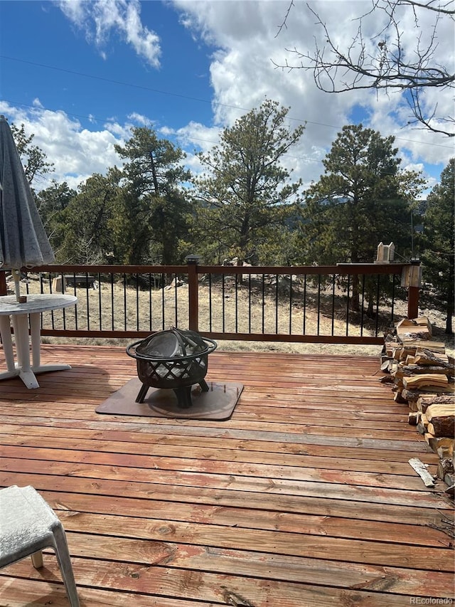 wooden terrace featuring an outdoor fire pit