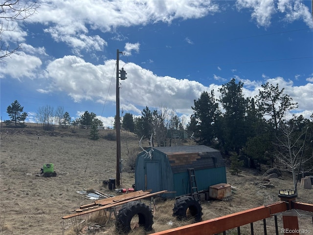 view of yard with a storage unit and a rural view