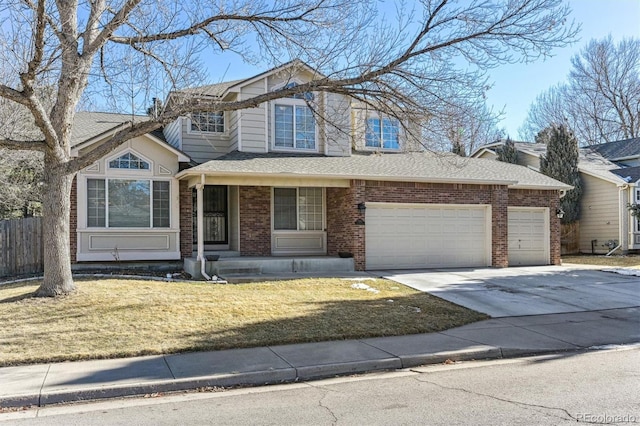 traditional-style house featuring brick siding, fence, a garage, driveway, and a front lawn