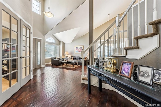 entryway with french doors, stairway, a towering ceiling, wood finished floors, and baseboards