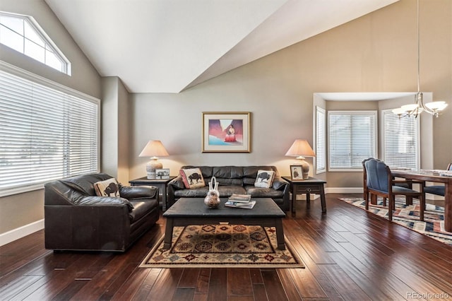 living area with a chandelier, dark wood-style flooring, high vaulted ceiling, and baseboards