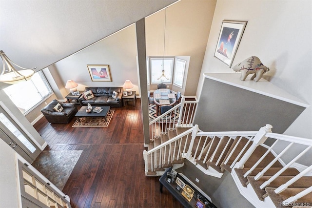 interior space featuring high vaulted ceiling, stairway, wood-type flooring, and baseboards