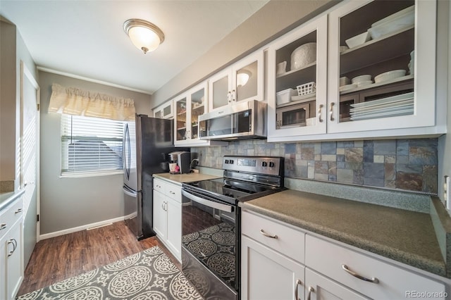 kitchen featuring white cabinets, stainless steel appliances, dark hardwood / wood-style flooring, and decorative backsplash