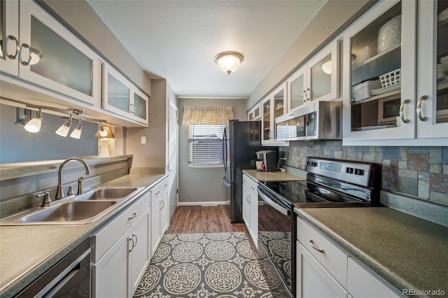 kitchen with appliances with stainless steel finishes, sink, backsplash, light wood-type flooring, and white cabinets