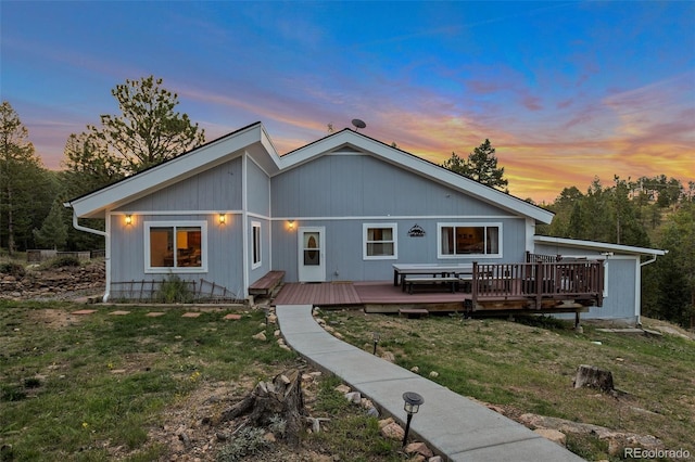 11348 Ranch Elsie Rd, Golden, CO 80403 - back of property at dusk featuring a lawn and a deck