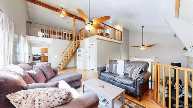 11348 Ranch Elsie Rd, Golden, CO 80403 - living room featuring a ceiling fan, stairs, light wood finished floors, and high vaulted ceiling