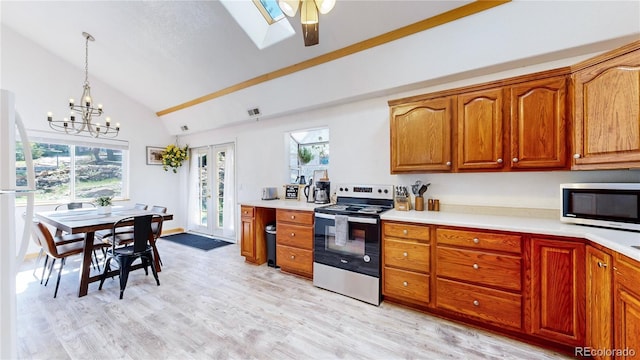 11348 Ranch Elsie Rd, Golden, CO 80403 - kitchen featuring brown cabinetry, light countertops, appliances with stainless steel finishes, and vaulted ceiling with skylight