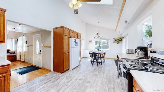 11348 Ranch Elsie Rd, Golden, CO 80403 - kitchen with freestanding refrigerator, brown cabinetry, light wood finished floors, ceiling fan with notable chandelier, and range with electric stovetop