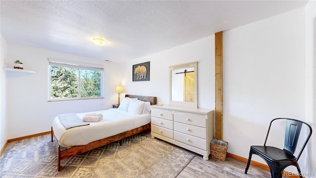 11348 Ranch Elsie Rd, Golden, CO 80403 - bedroom featuring baseboards, light wood-style floors, and a textured ceiling
