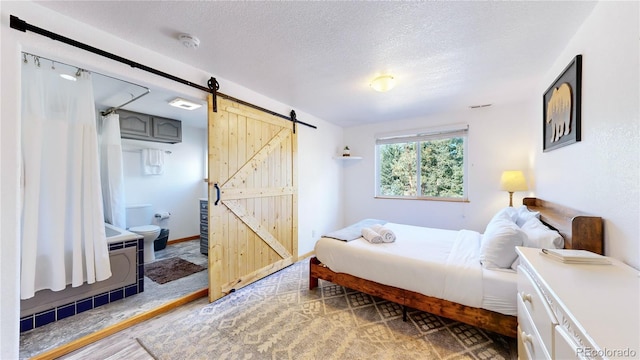 11348 Ranch Elsie Rd, Golden, CO 80403 - bedroom with a textured ceiling and a barn door