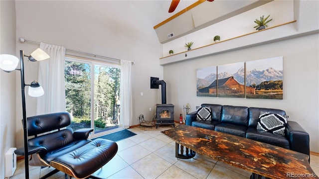 11348 Ranch Elsie Rd, Golden, CO 80403 - tiled living room with a ceiling fan, a wood stove, high vaulted ceiling, and visible vents