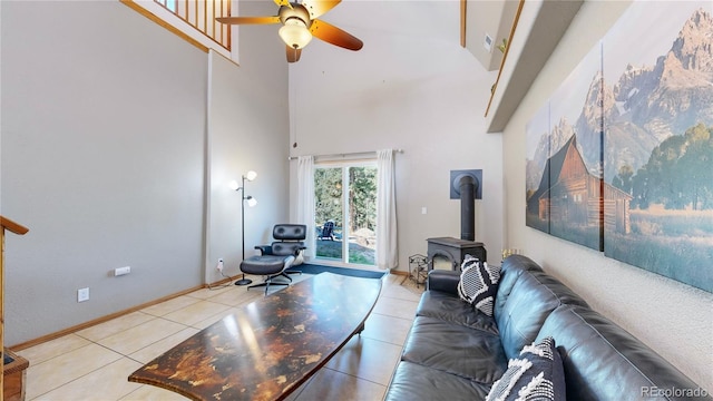 11348 Ranch Elsie Rd, Golden, CO 80403 - living room featuring a wood stove, a ceiling fan, light tile patterned floors, a high ceiling, and baseboards