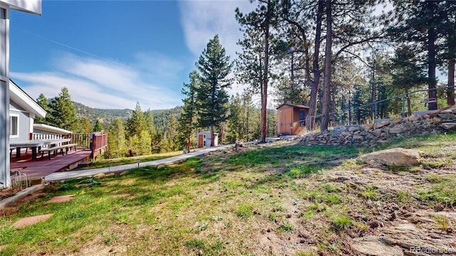 11348 Ranch Elsie Rd, Golden, CO 80403 - view of yard featuring a storage unit, a deck, and an outbuilding