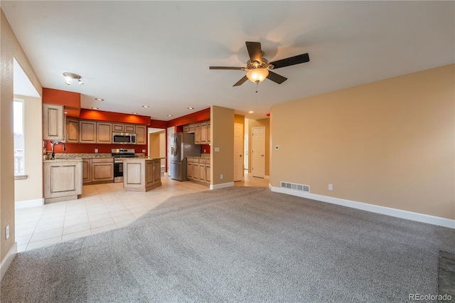 kitchen featuring stainless steel appliances, ceiling fan, sink, light tile patterned floors, and a kitchen island