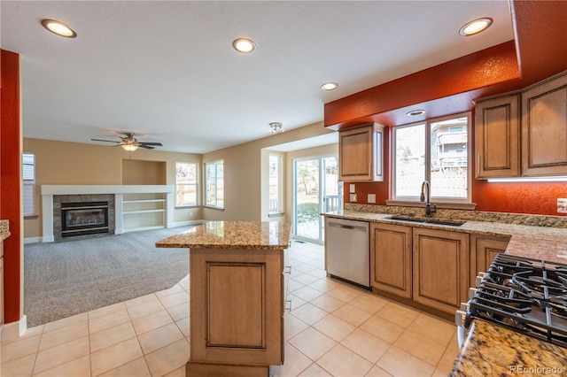 kitchen featuring light carpet, sink, light stone countertops, appliances with stainless steel finishes, and a kitchen island