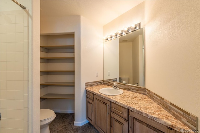 bathroom with a shower, vanity, and toilet