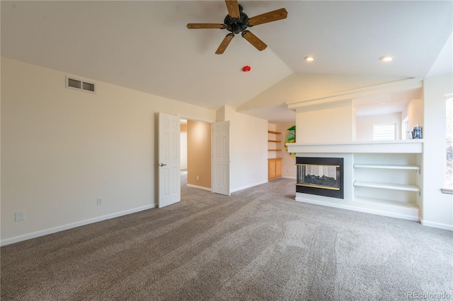 unfurnished living room featuring a multi sided fireplace, built in features, and carpet floors