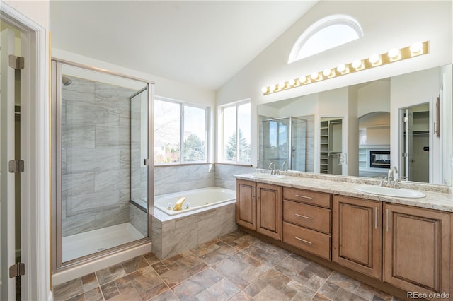 bathroom featuring separate shower and tub, vanity, and lofted ceiling