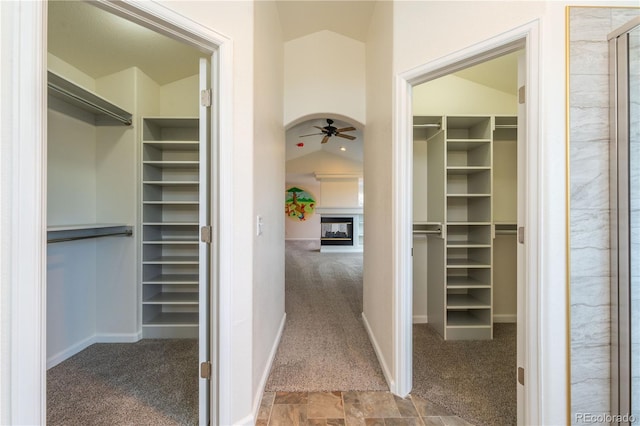 walk in closet featuring carpet flooring, ceiling fan, and vaulted ceiling